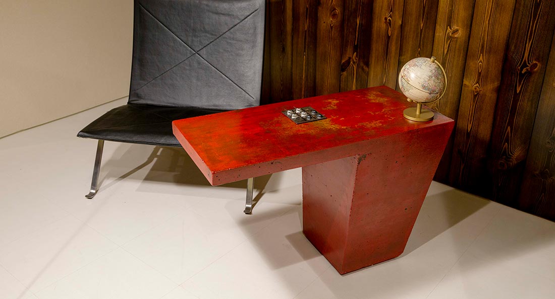 赤い素地塗りで仕上げたコンクリートの重さを利用したデザインテーブル