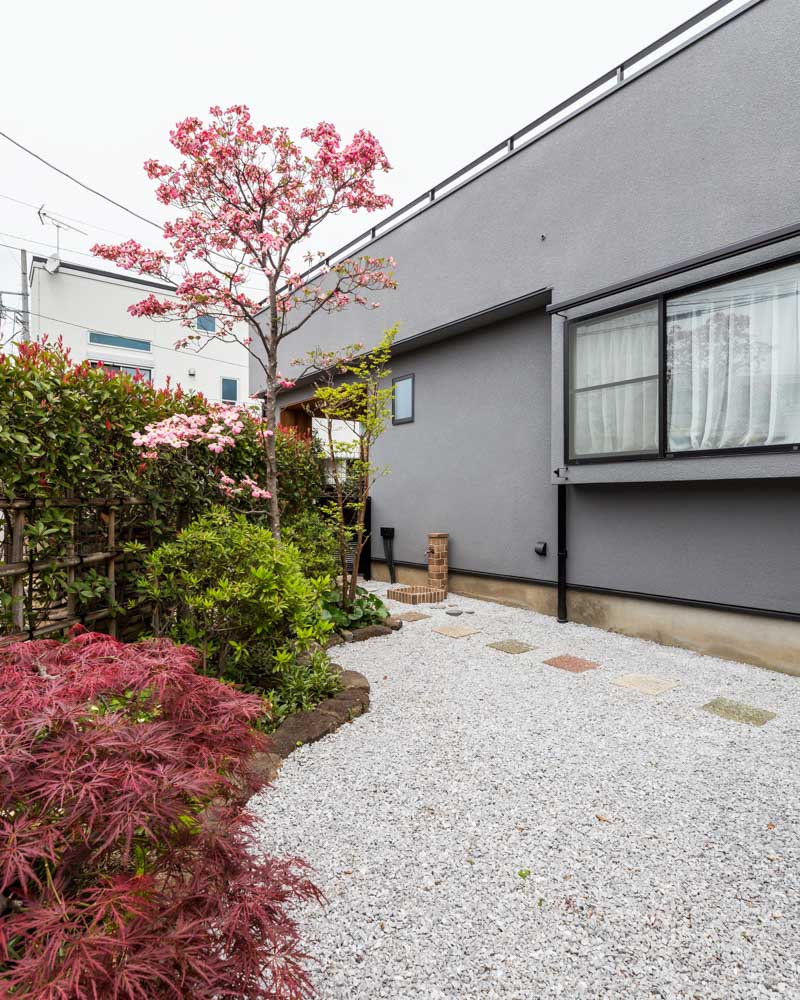 外壁のグレーが調和する庭の様子