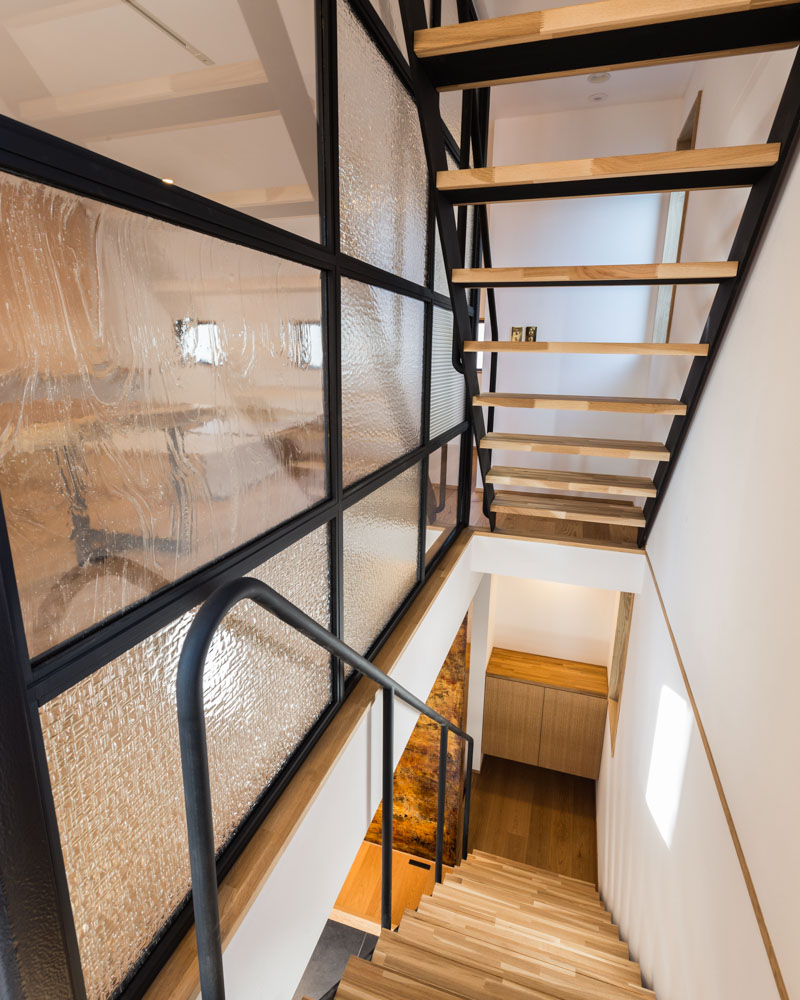 オーク系の床に黒のスチールを合わせたスケルトン階段の様子