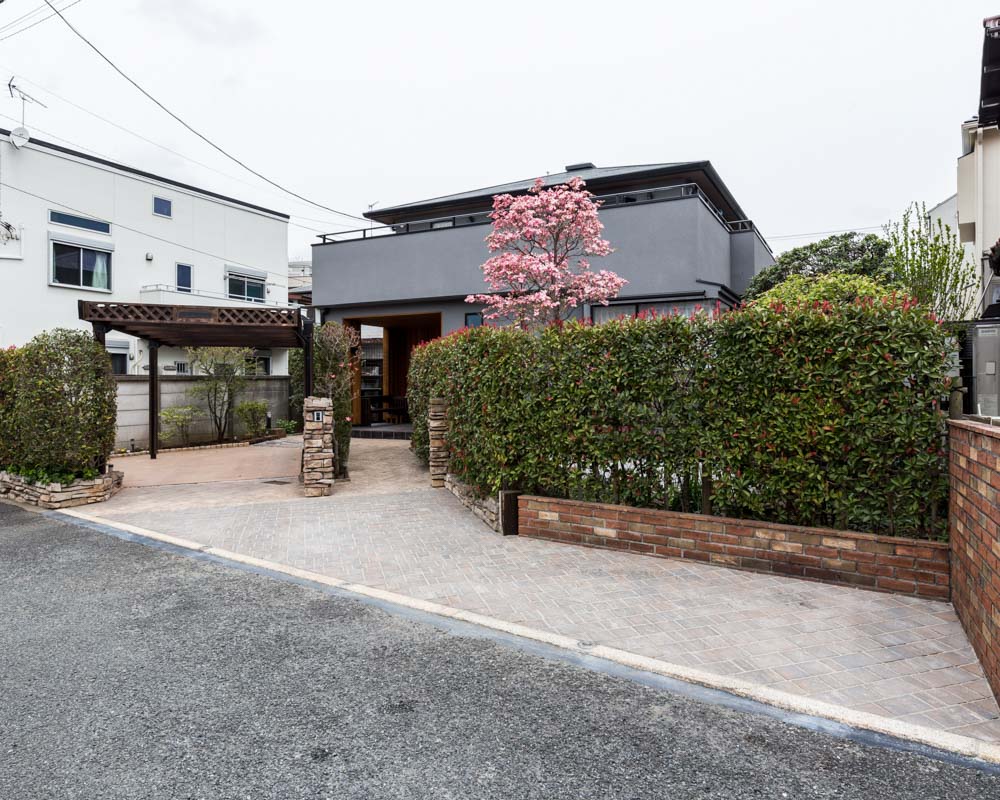 緑豊かな庭に調和するシックな色味の塗り壁に生まれ変わった外観の様子