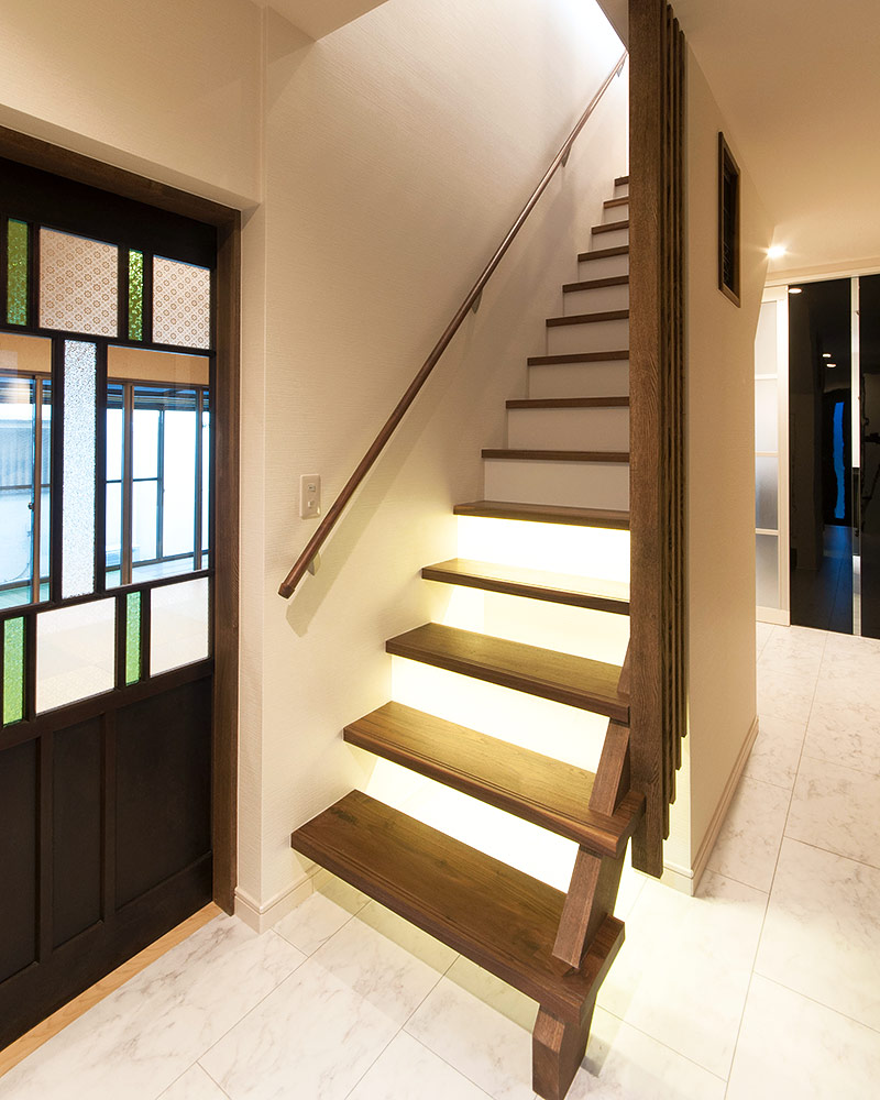 アンティークガラスの建具の横にあるブラックウォールナットの階段。