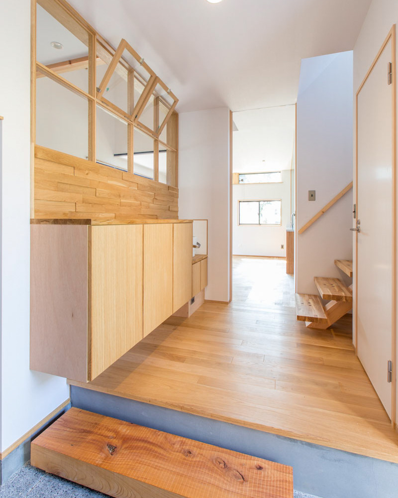 洗い出し仕上げの玄関土間。すべらかな立ち上がり部は墨モルタルを採用