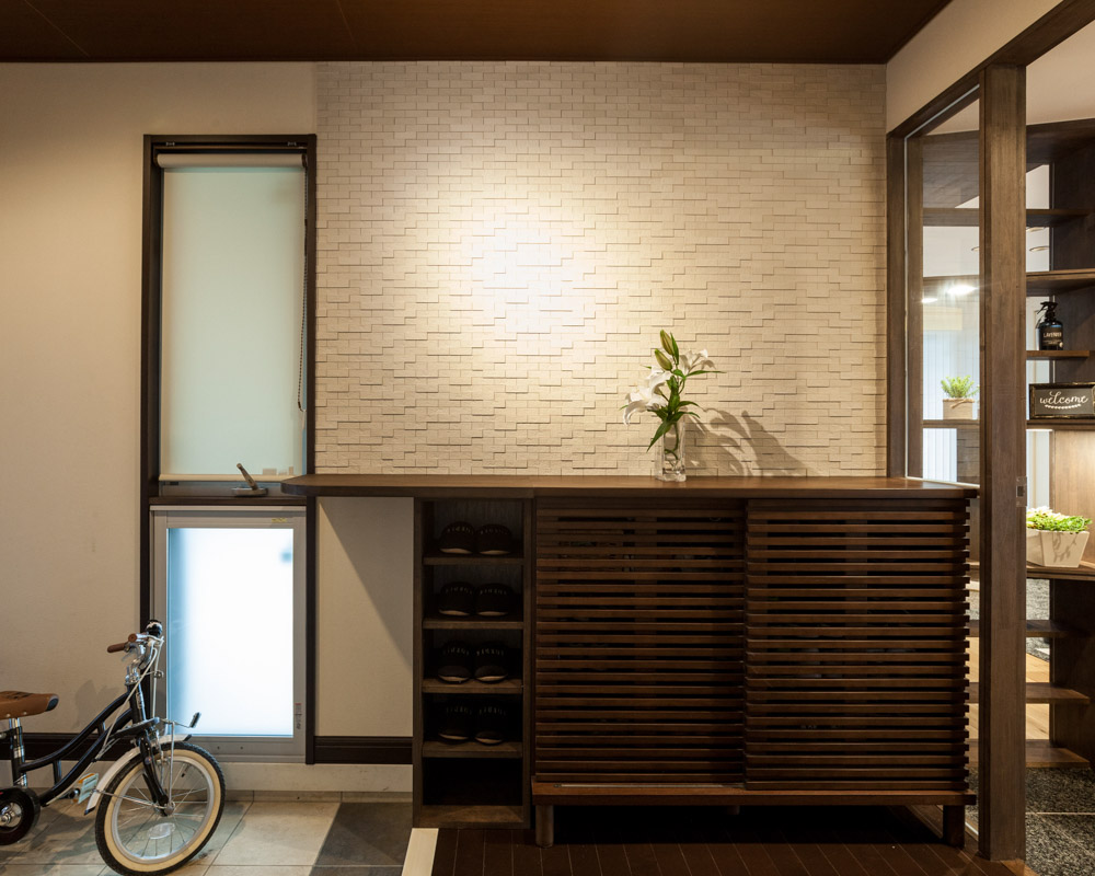 大容量の靴箱は大工が作った製作家具。背面の壁はエコカラットを採用したアクセントウォール。