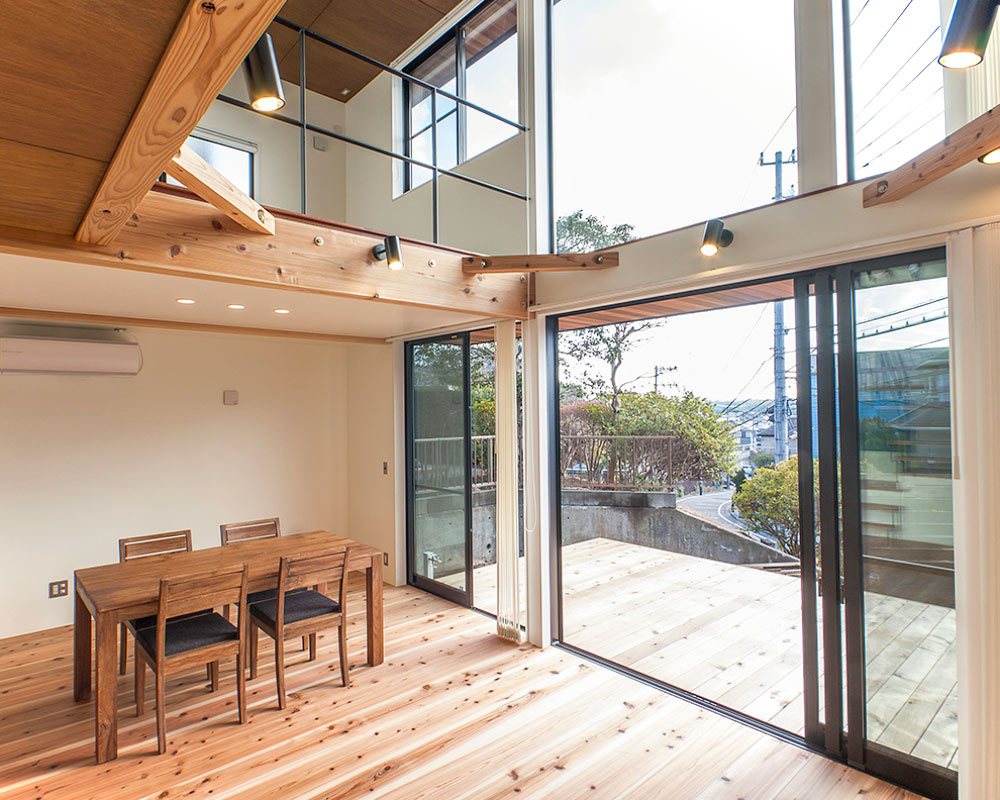 リビングの吹き抜け部分は大開口となり、ウッドデッキとフラットに繋がっている。