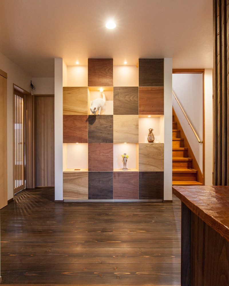 広々とした廊下。玄関正面にパネル上の飾り棚を配置。猫用のドアを一体化させた製作家具