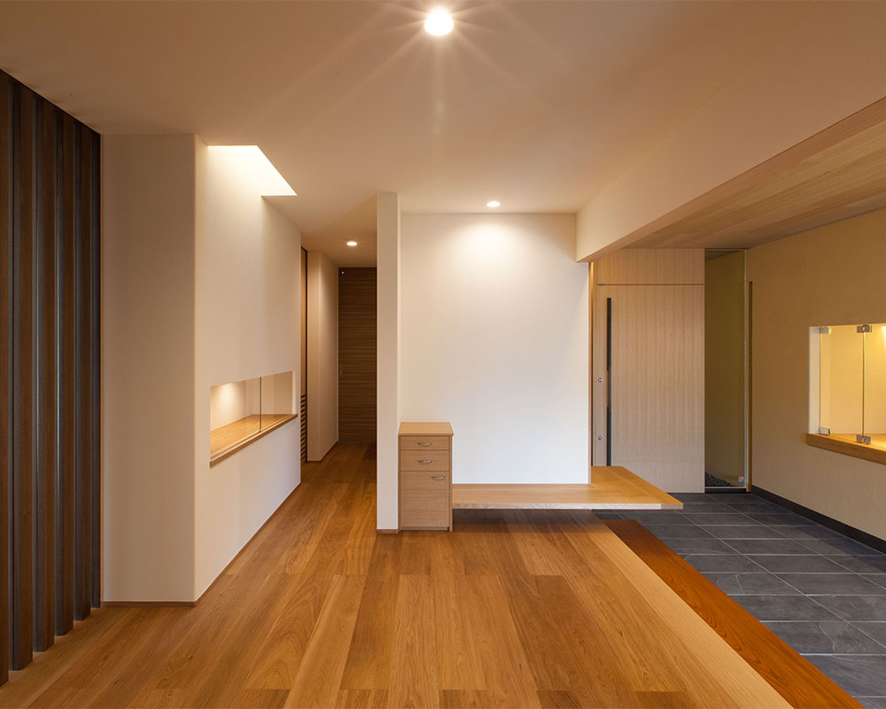 来客用のキャビネットとベンチを造りつけた玄関ホール