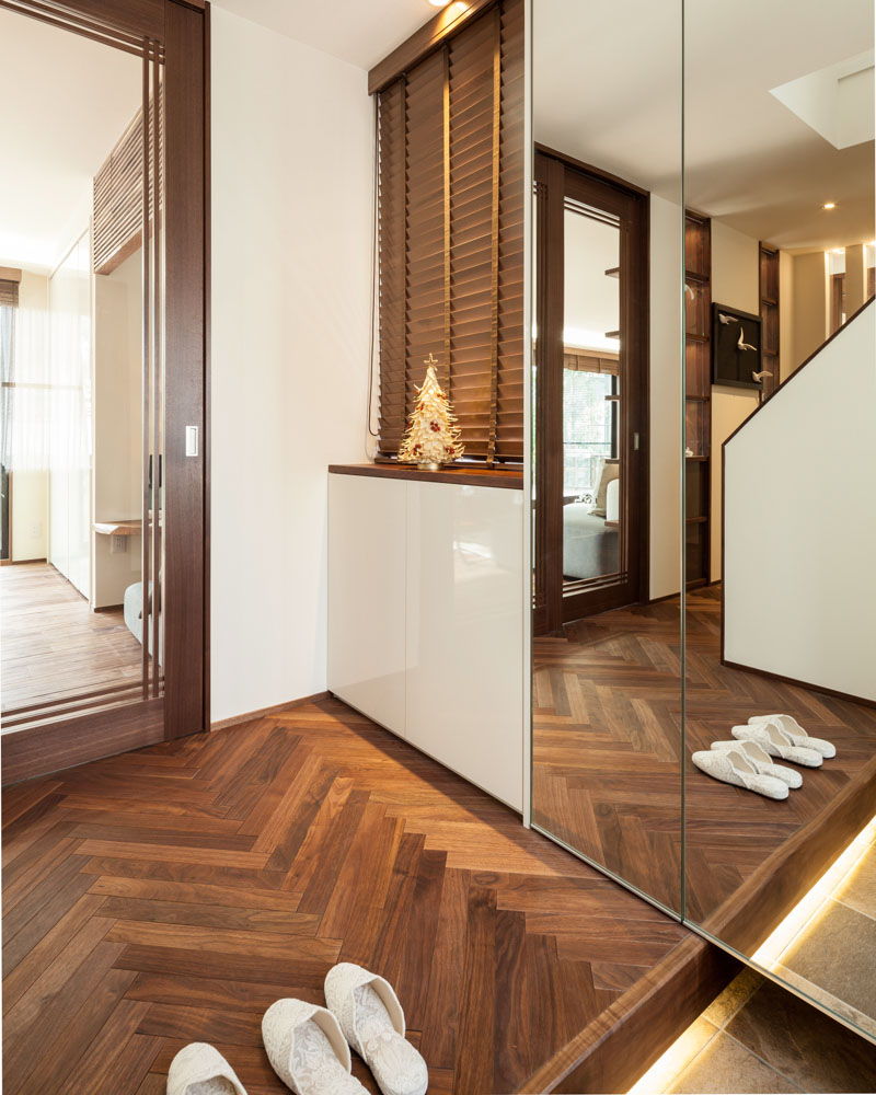 ブラックウォールナットをヘリンボーン貼りしたエントランスはメリハリがある。