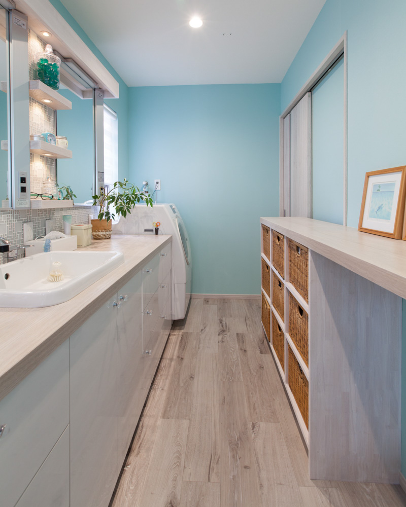 大工が作ったオリジナル洗面台。壁面収納にはお施主様の「藤かご」をリメイク