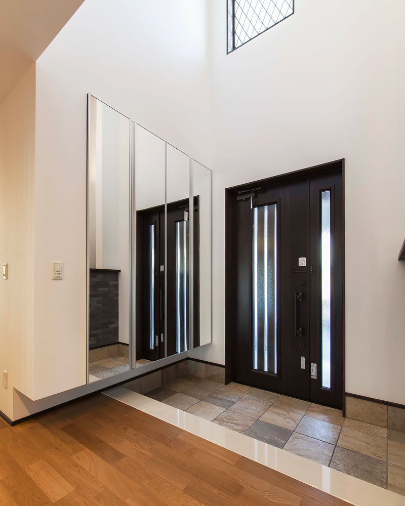 吹き抜けと鏡面シューズクローゼットで広々とした印象の玄関