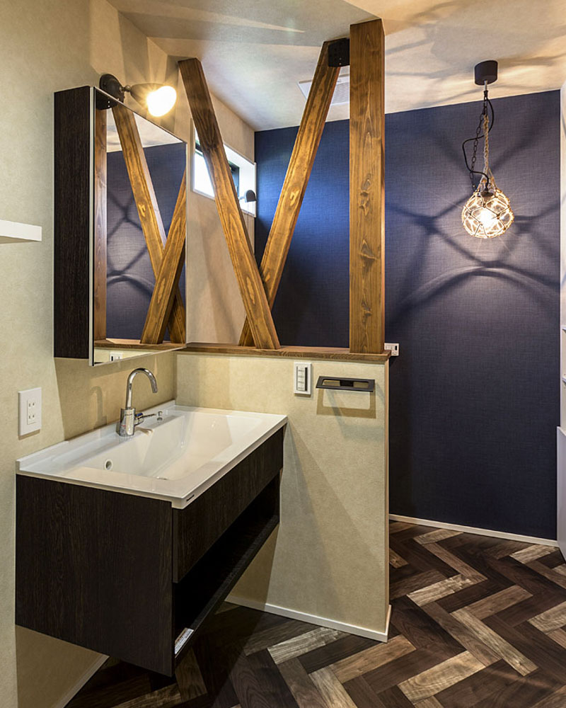 洗面脱衣所と一体化したトイレ。壁で仕切らず、腰壁を採用した。