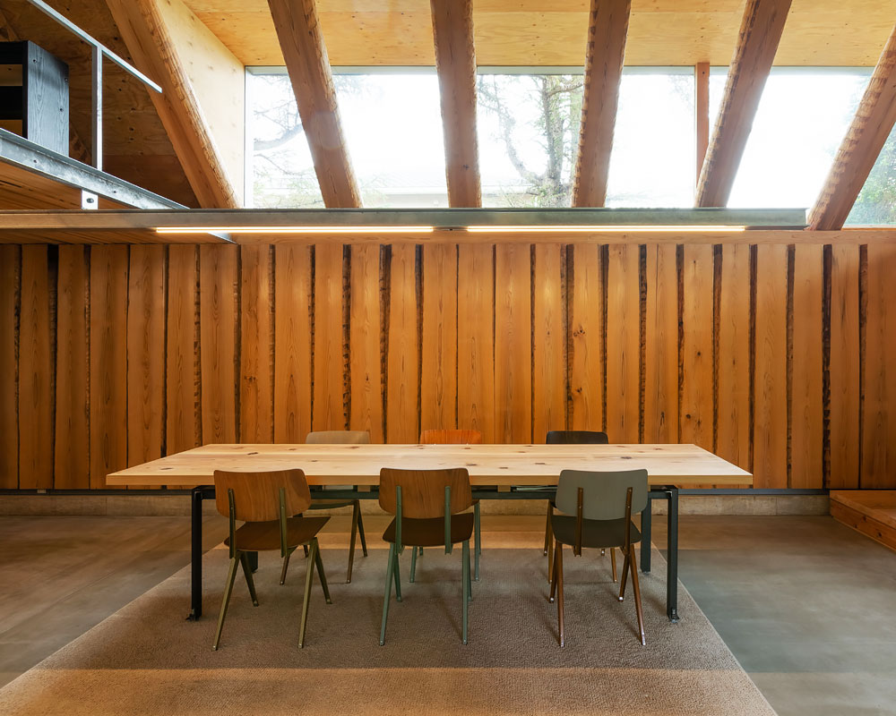 吹き抜け上部の破風窓から明るい陽射しが降り注ぐダイニング