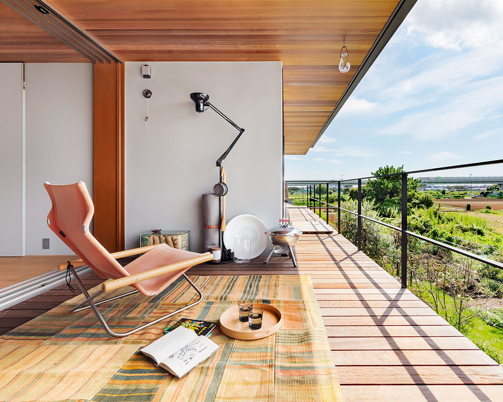 庭先アウトドアの家：ウッドデッキを敷いたバルコニー