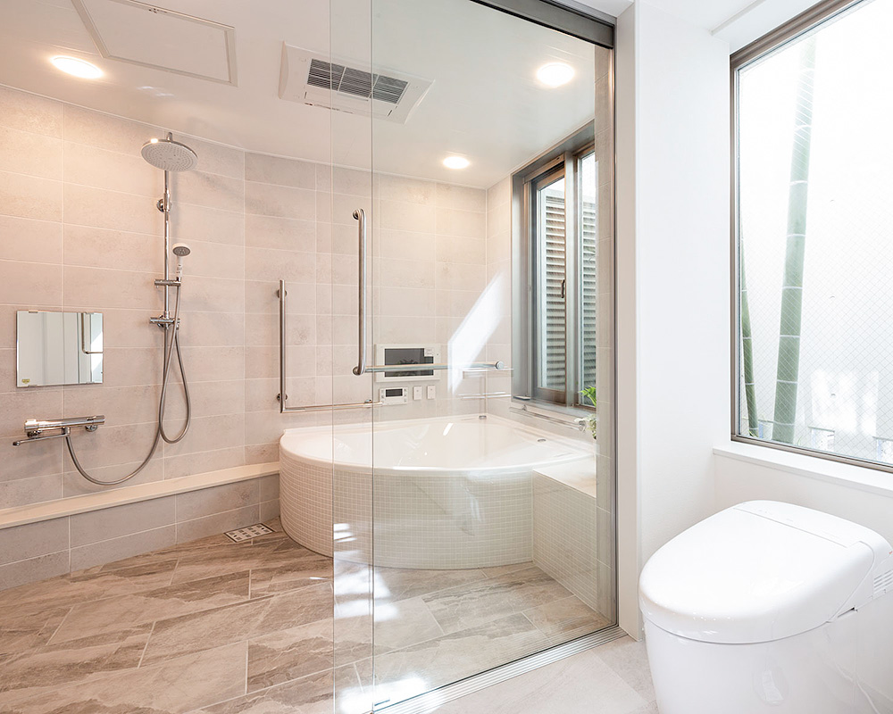 外の緑も楽しめる全面ガラスの扉のバスルーム