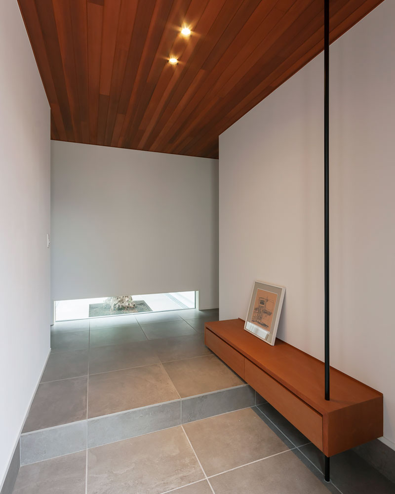 土間とホールに同一のタイルを用いた玄関